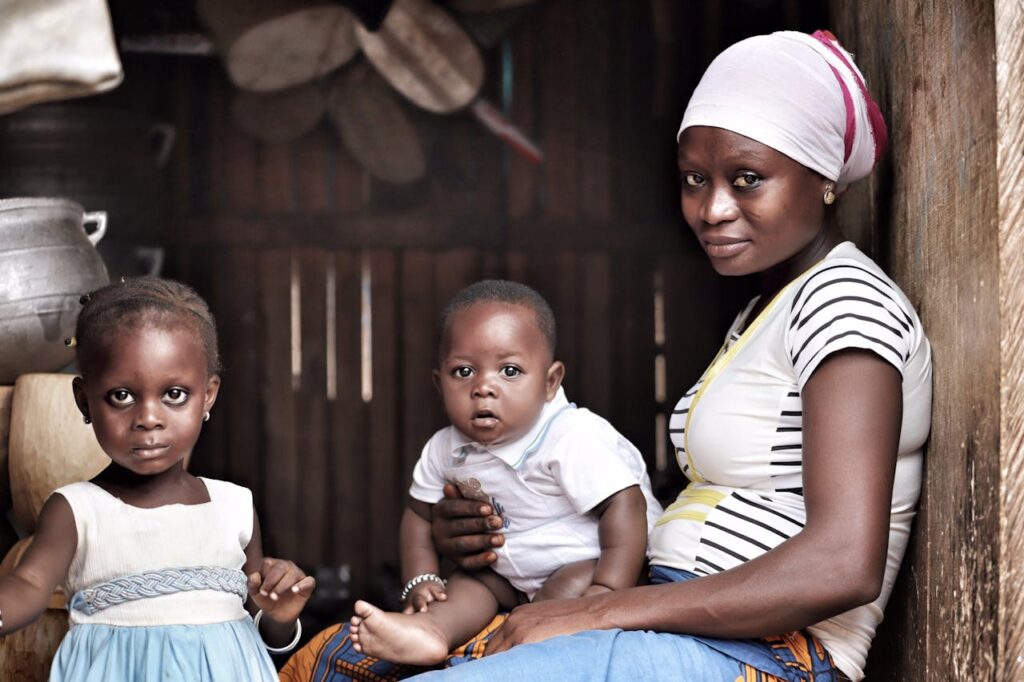 Woman in White and Black Shirt Holding a Boy in White Shirt